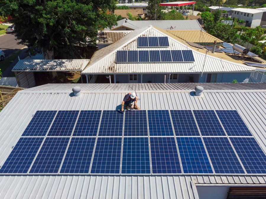 Solar Panel Technician Installing Solar Panels On Roof — Electrical Contractors in Grafton, NSW