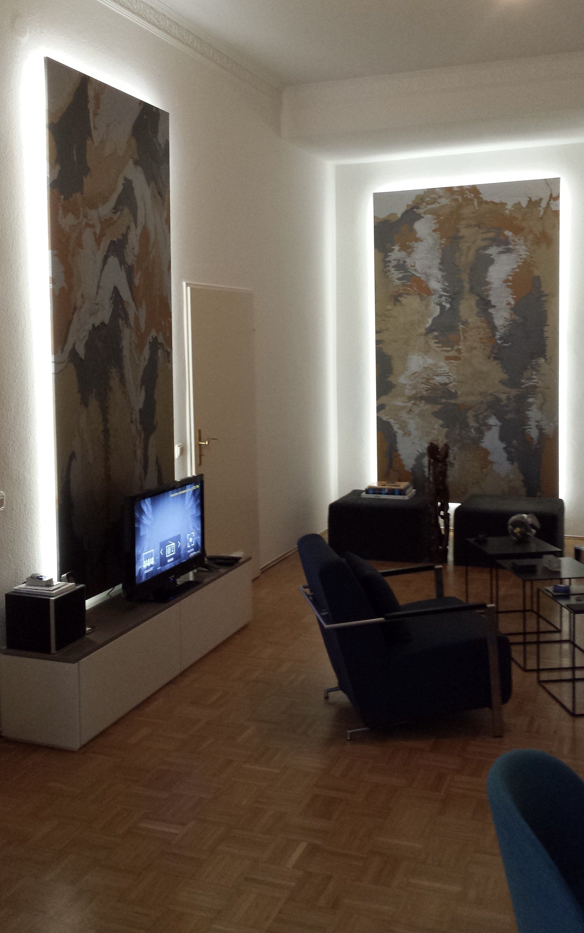 Een woonkamer met een flatscreen-tv en kunst aan de muur