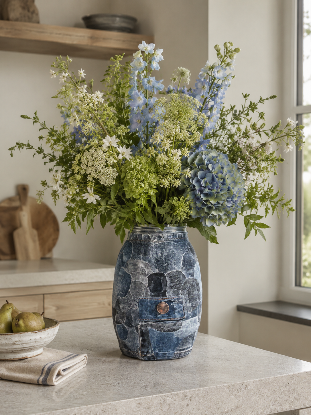 Blauwe keramische vaas met wilde bloemen op het aanrecht bij het raam.