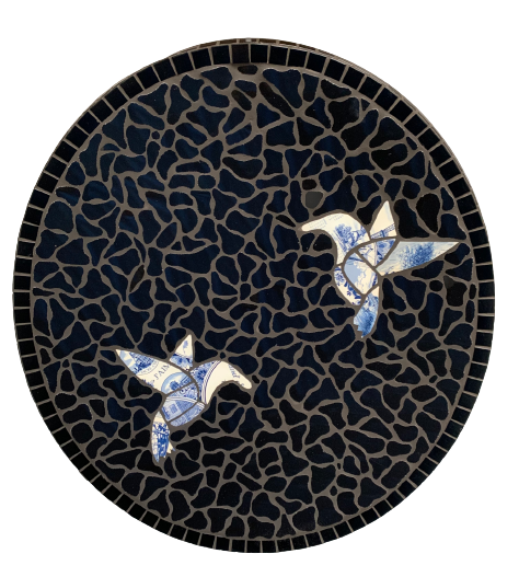 Een tegelmozaïek van twee delfts blauwe vogels op een zwarte achtergrond