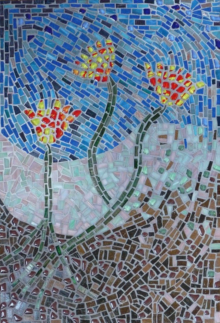 Een close-up van een mozaïek van bloemen op een muur.