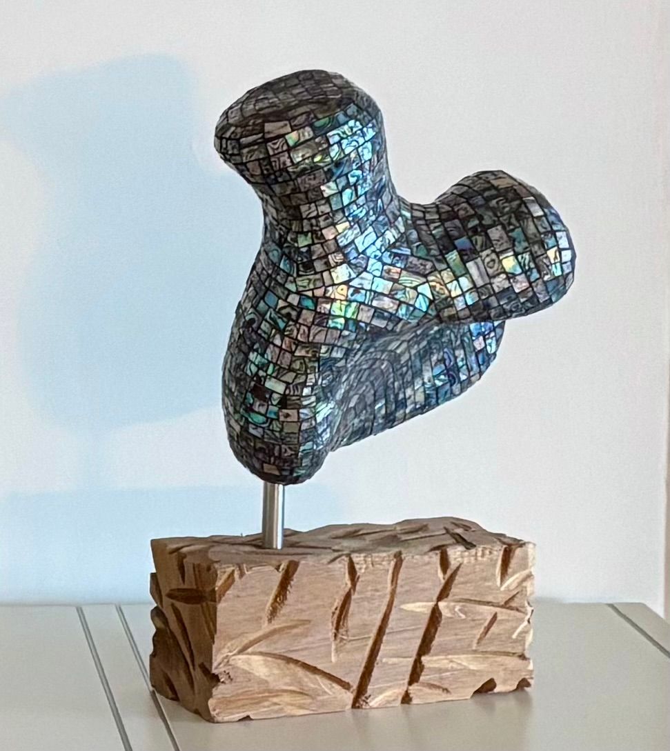 Een beeld met pearlmozaïek oip een houten sokkel