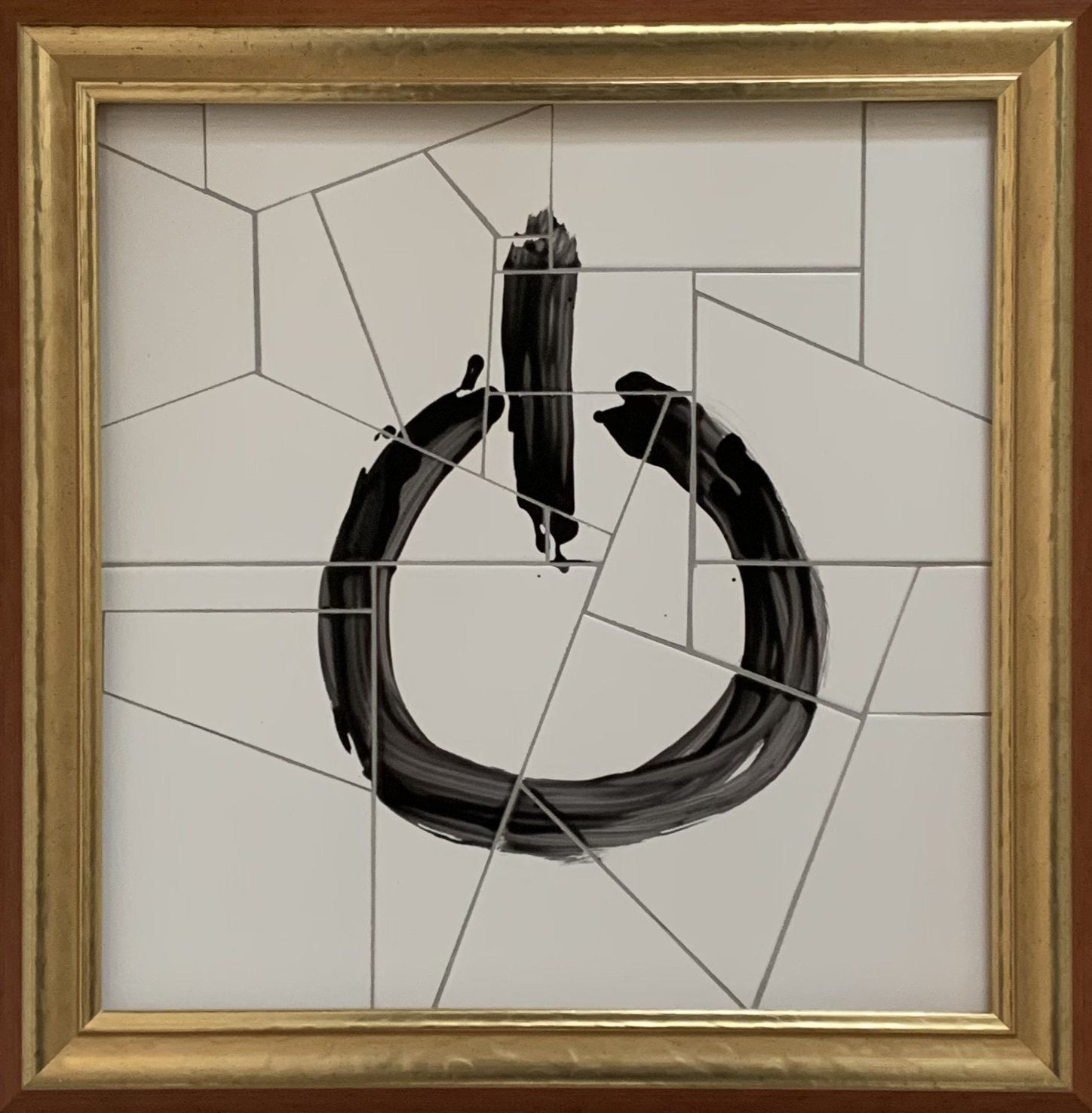 Een tegelmozaïek van een aan/uit-knop in een gouden lijst