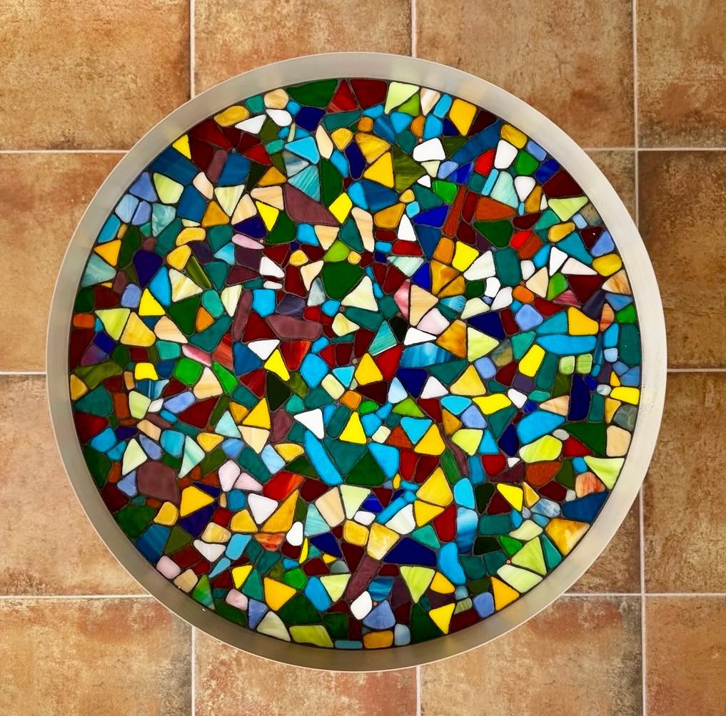 Een ronde schaal met een glas-in-loodontwerp erop