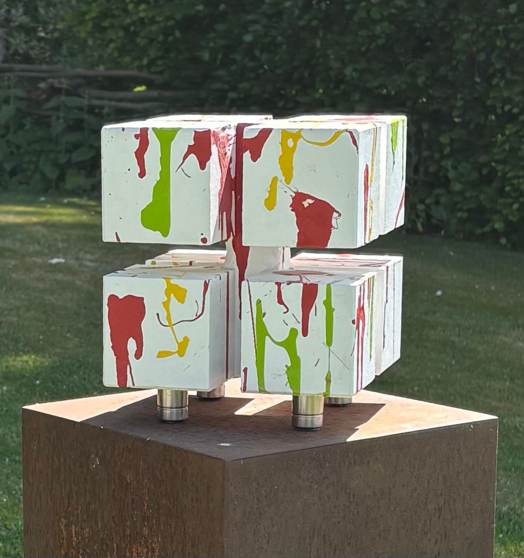 Een witte kubus met rode, groene en gele verf erop