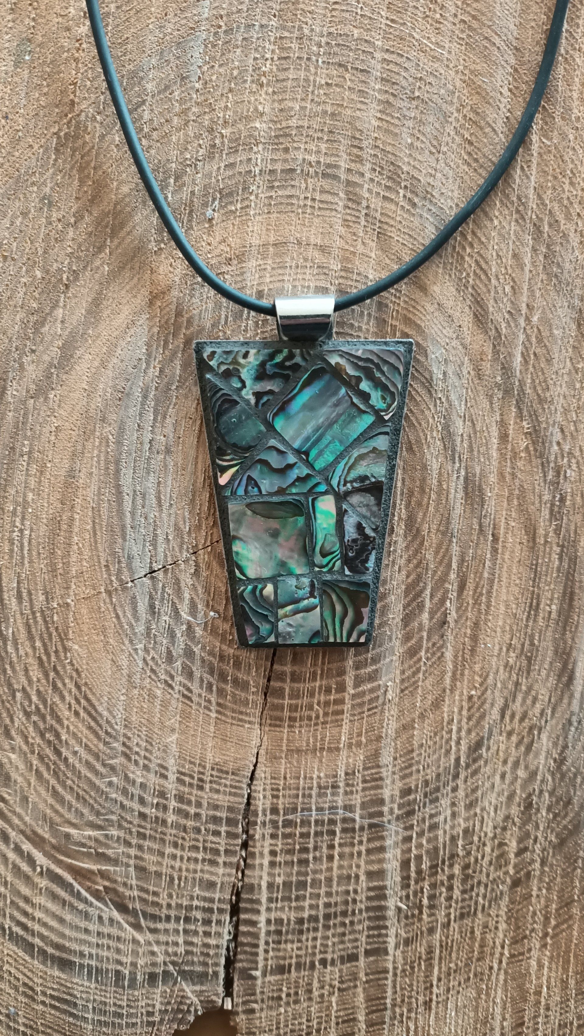 Een close-up van een ketting met een hanger op een houten oppervlak.