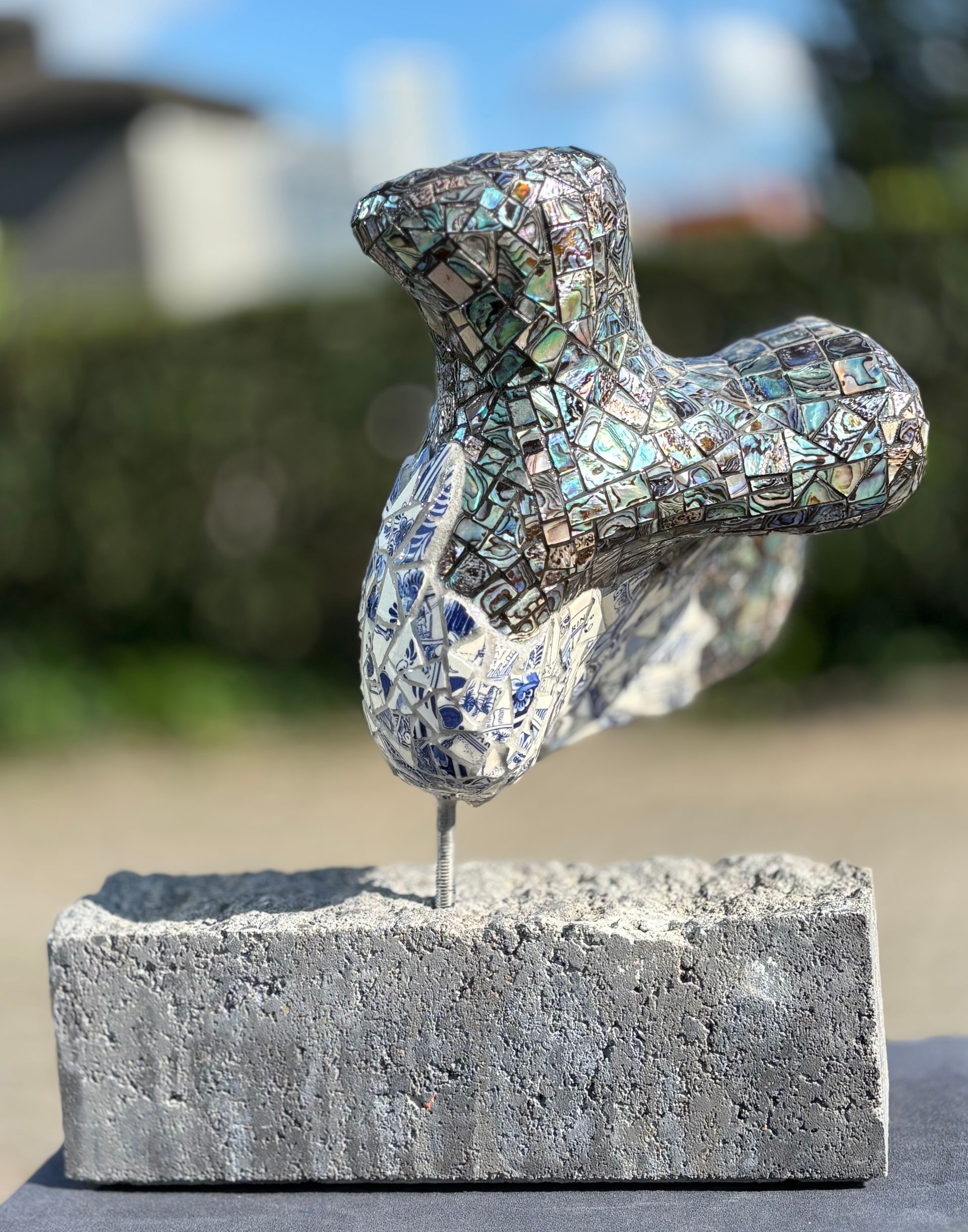 Een beeldje van een hart op een houten voetstuk op een witte achtergrond.