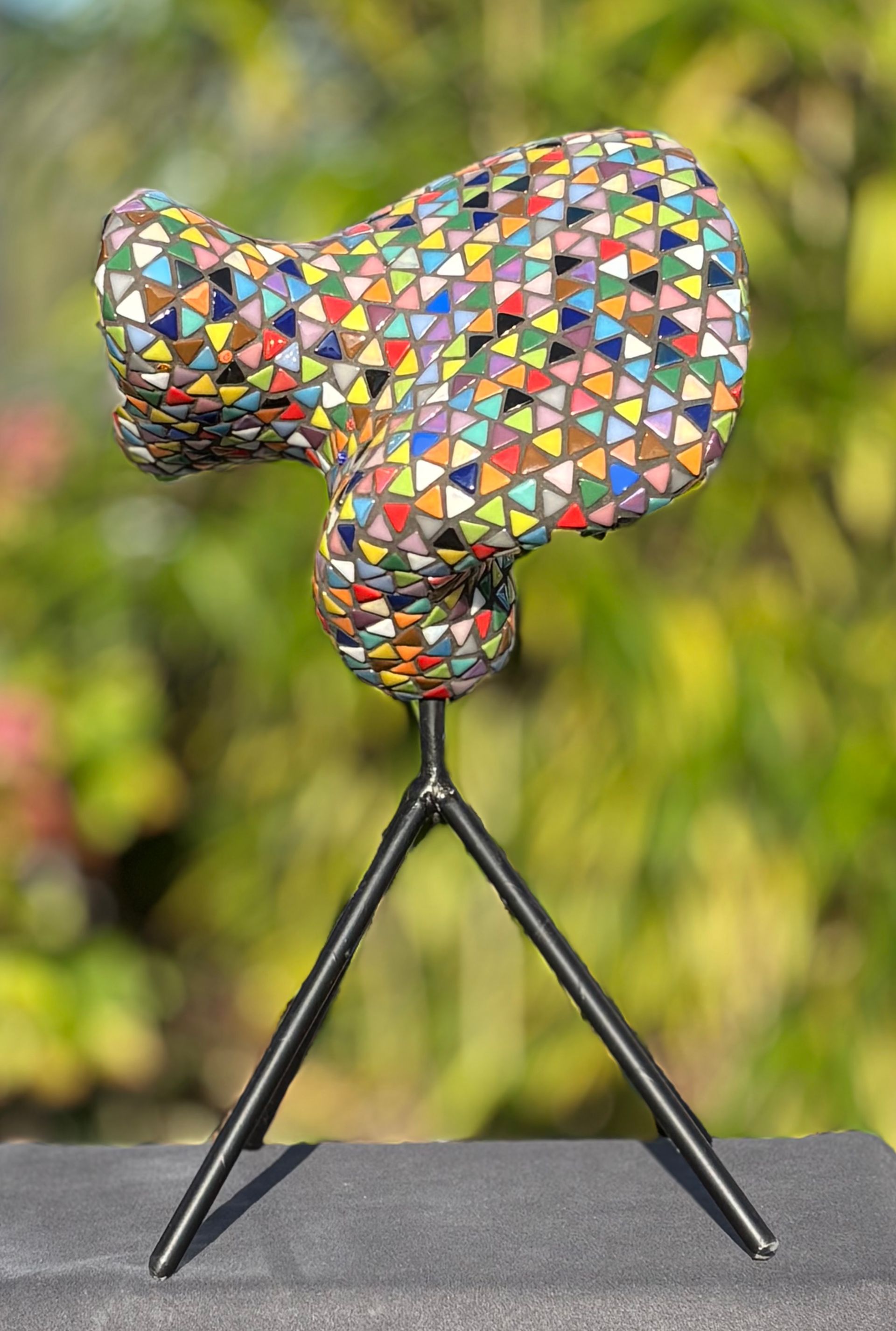 Een kleurrijk beeld staat op een statief op een tafel