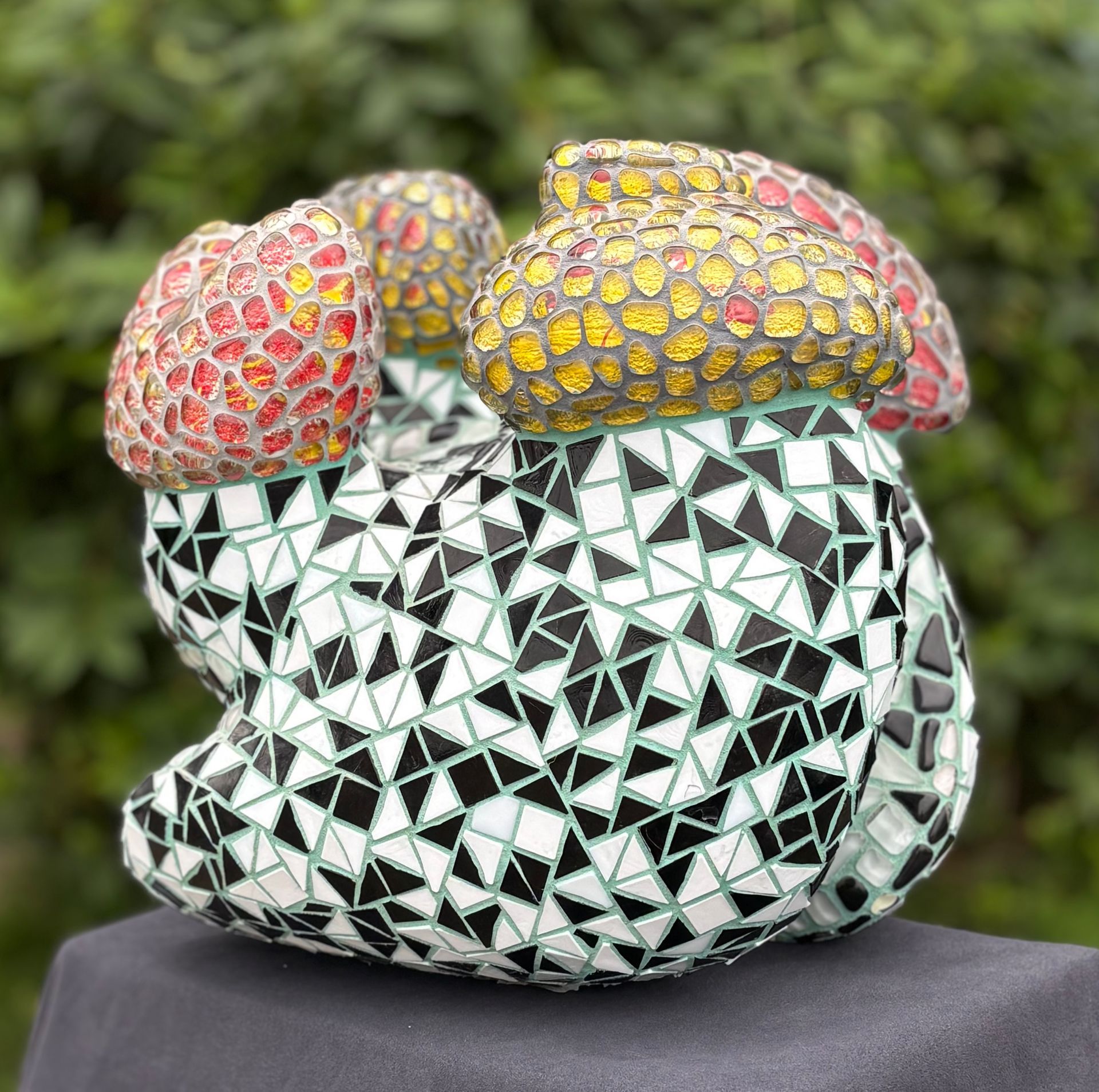 Een zwart-wit mozaïekbeeld met rode en gele uitsteeksels