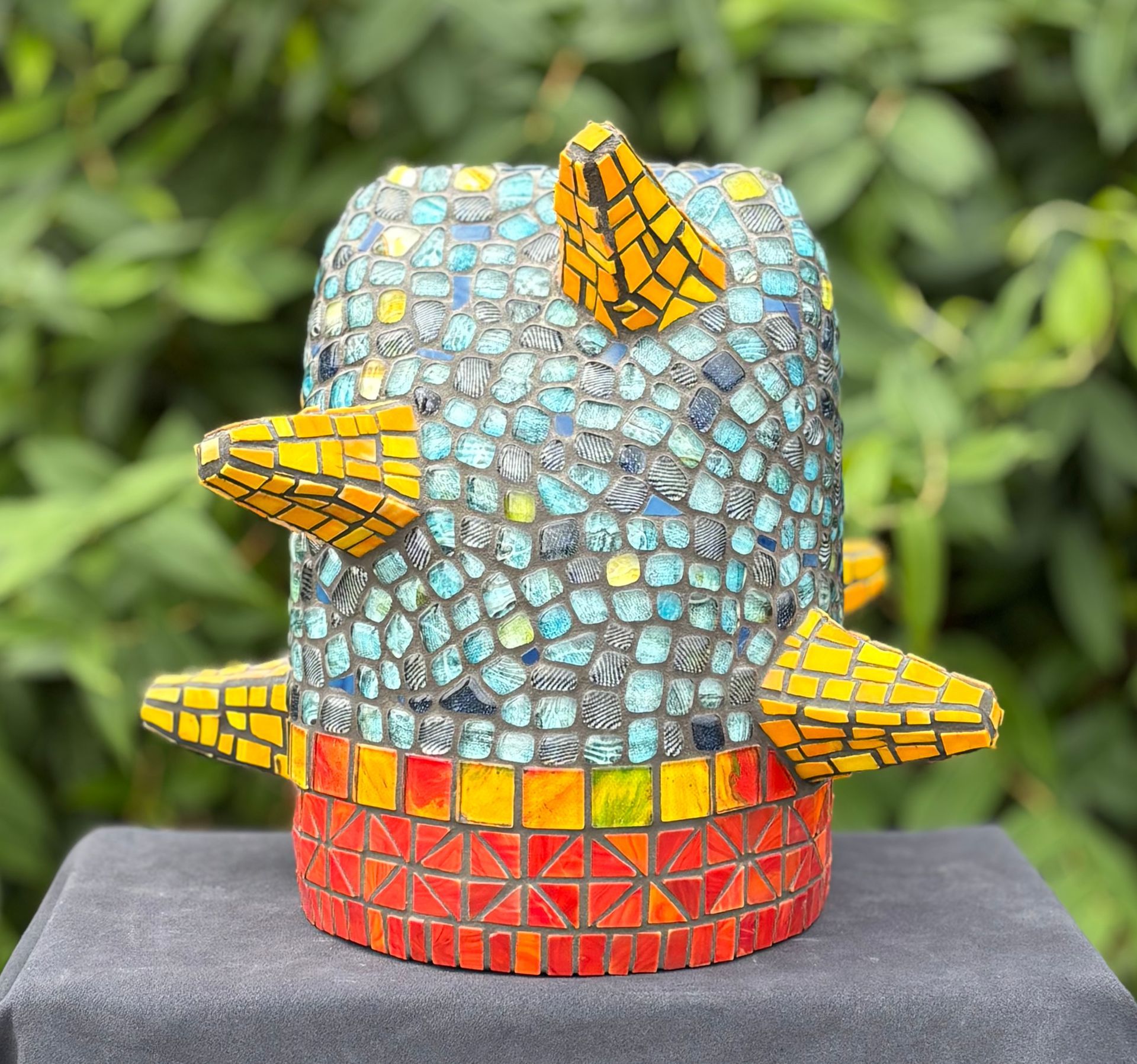 Een kleurrijk mozaïekbeeld van een vogelkop op een witte achtergrond