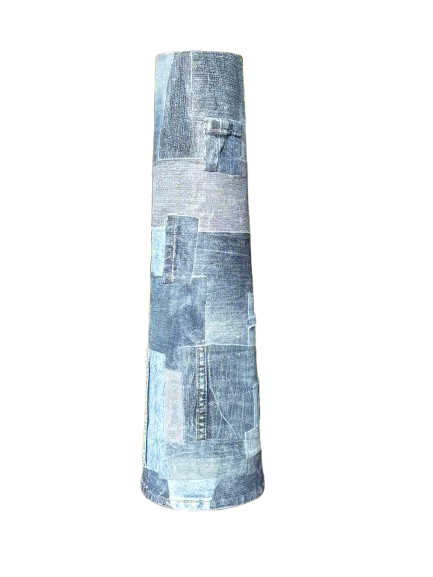Hoge, cilindervormige tas van blauw patchwork denim op een witte achtergrond.