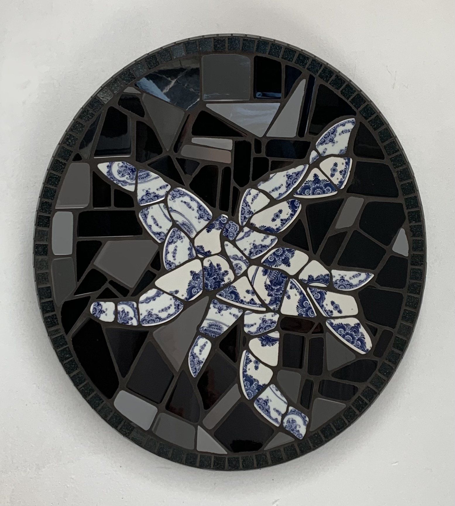 Een zwarte cirkel met daarop een blauwe en witte zeester