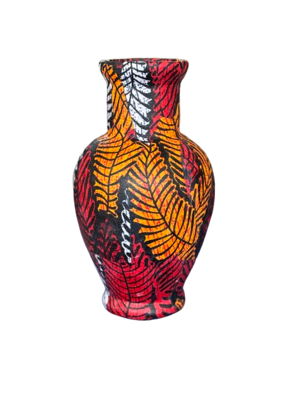 Kleurrijke keramische vaas met patroon van rode, oranje, zwarte en witte bladeren.