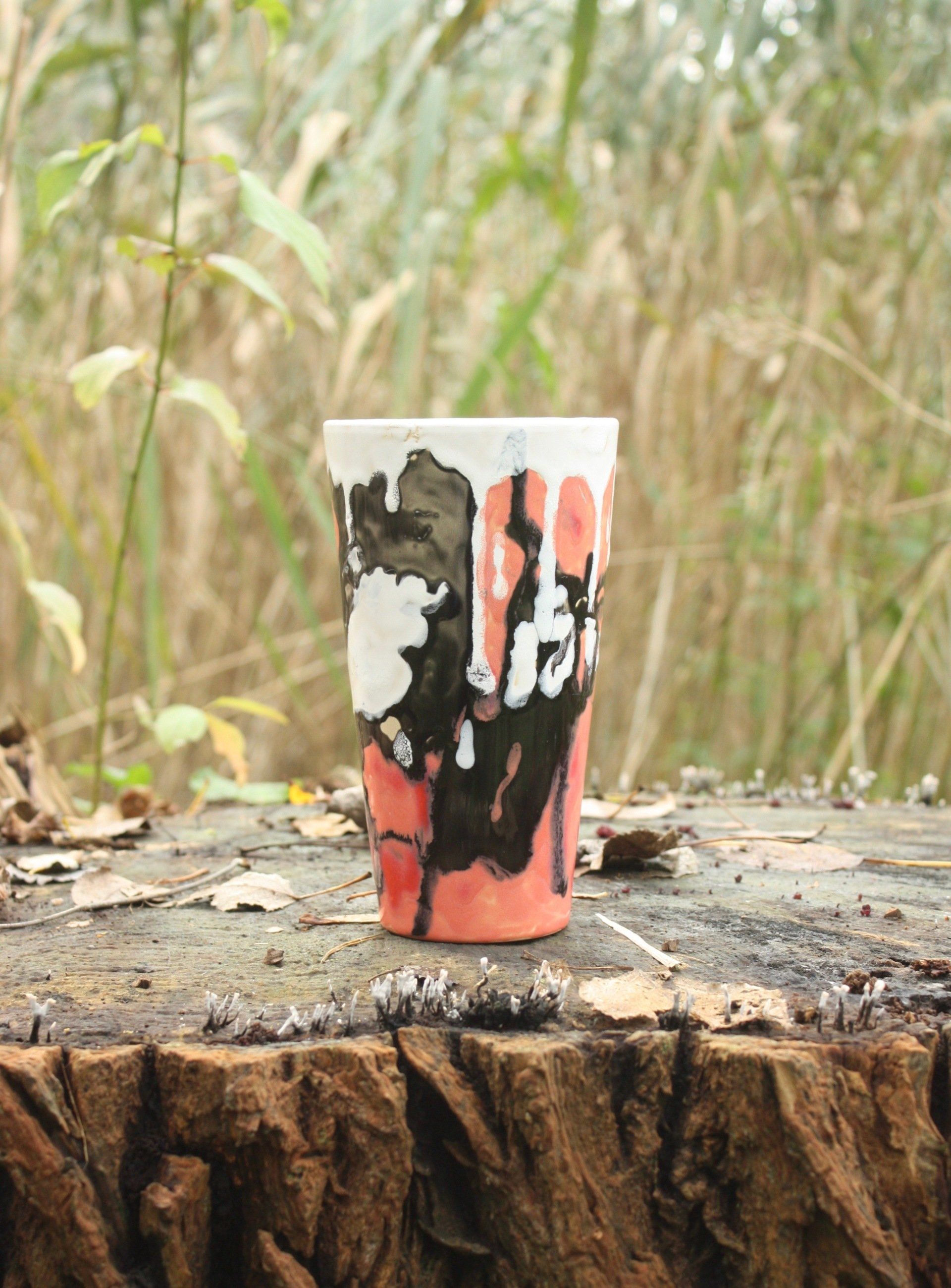 Er staat een vaas op een boomstronk.