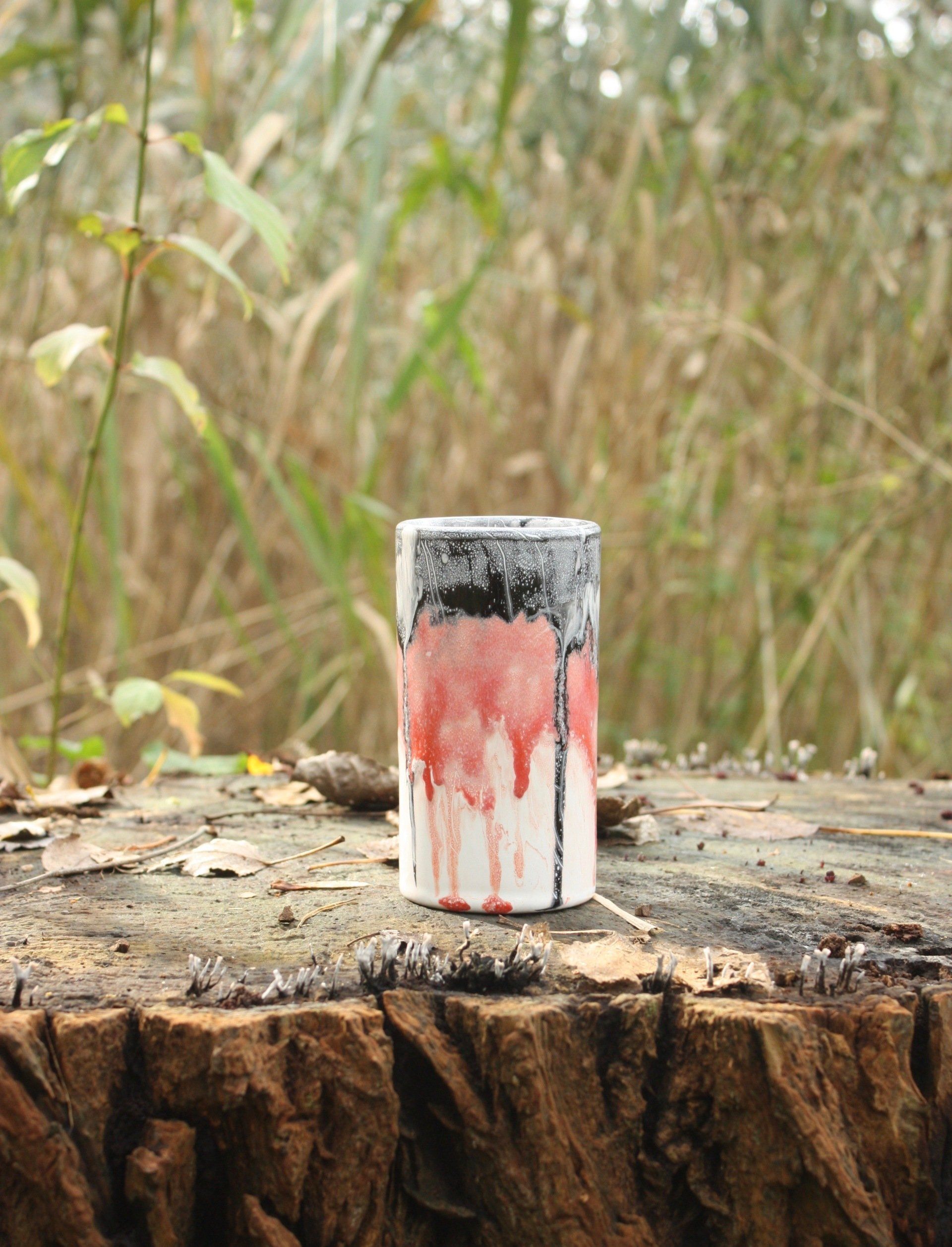 Een vaas staat op een boomstronk.