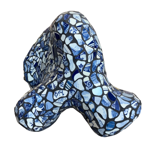 Een driedimensionale abstracte sculptuur, gemaakt van blauw-witte porseleinen mozaïekfragmenten tegen een witte achtergrond.