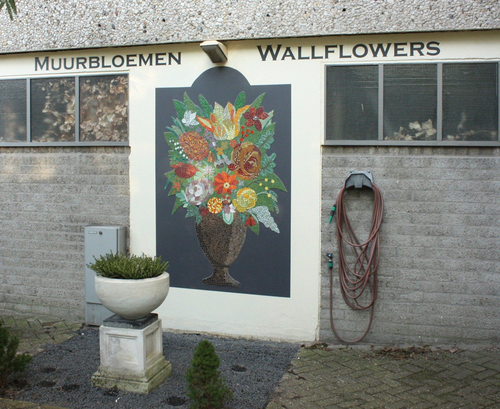 Een muur met een afbeelding van bloemen en de woorden muurbloemen erop