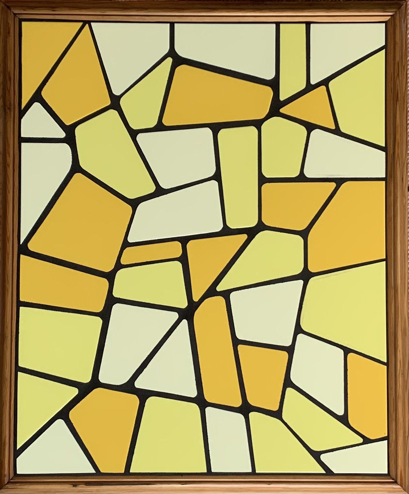 Een geel en wit tegelmozaïek in een houten lijst