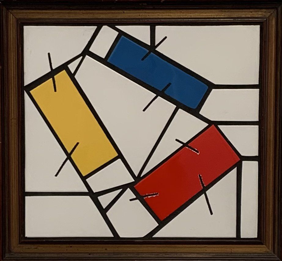 Een ingelijst schilderij met rood-gele en blauwe rechthoeken