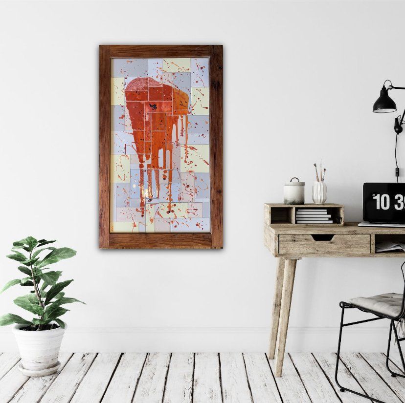 Een schilderij van een rode telefooncel hangt aan een muur boven een bureau