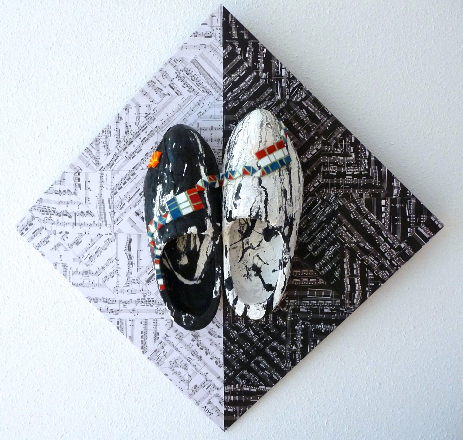 Een zwart-witte driehoek met daarop een paar klompen