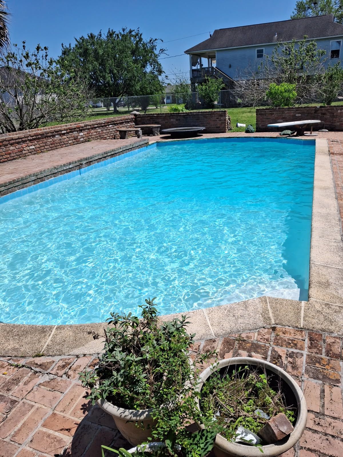 Two photos showing a swimming pool before and after cleaning. Pool has light blue water, concrete surround.