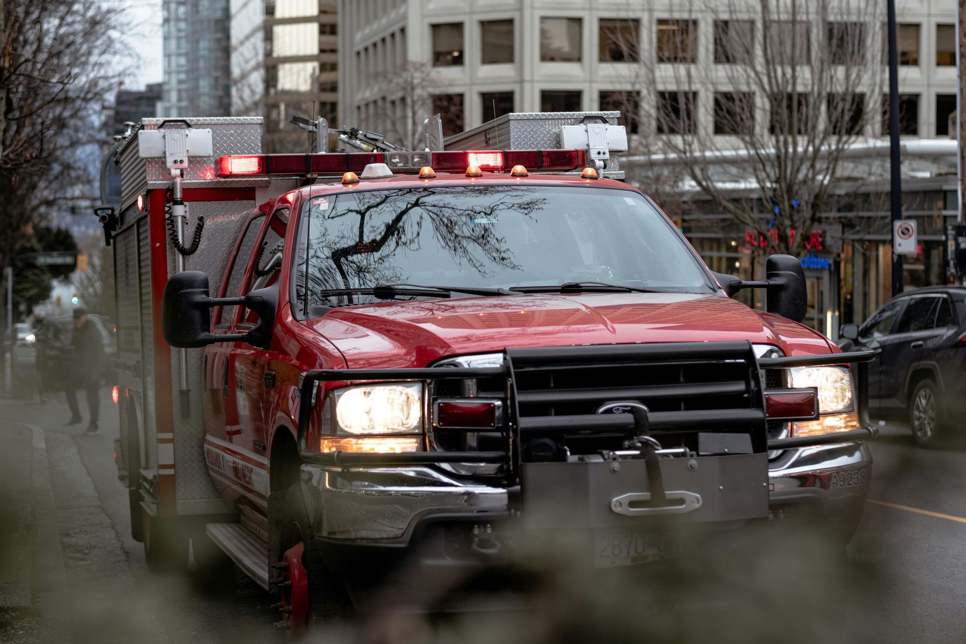 A red fire truck is driving down a city street.