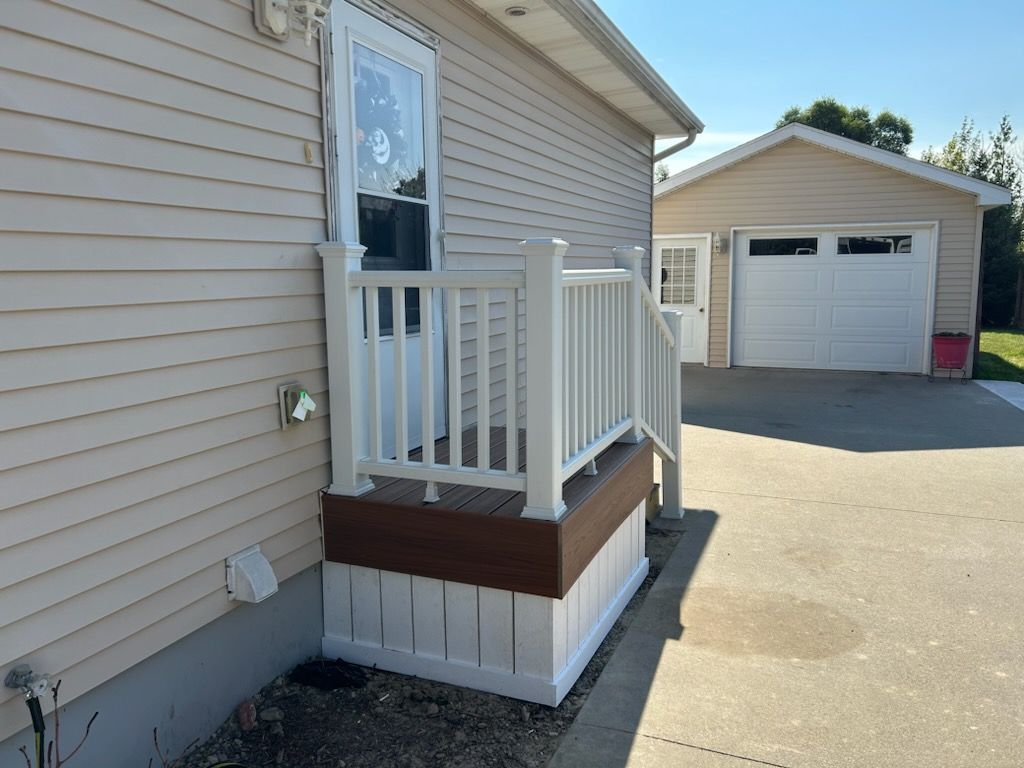 A mobile home with a porch and a garage.