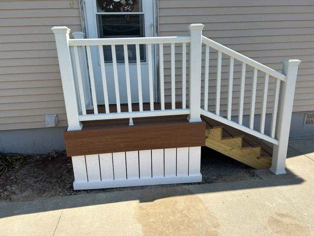 A white railing with stairs leading up to a house