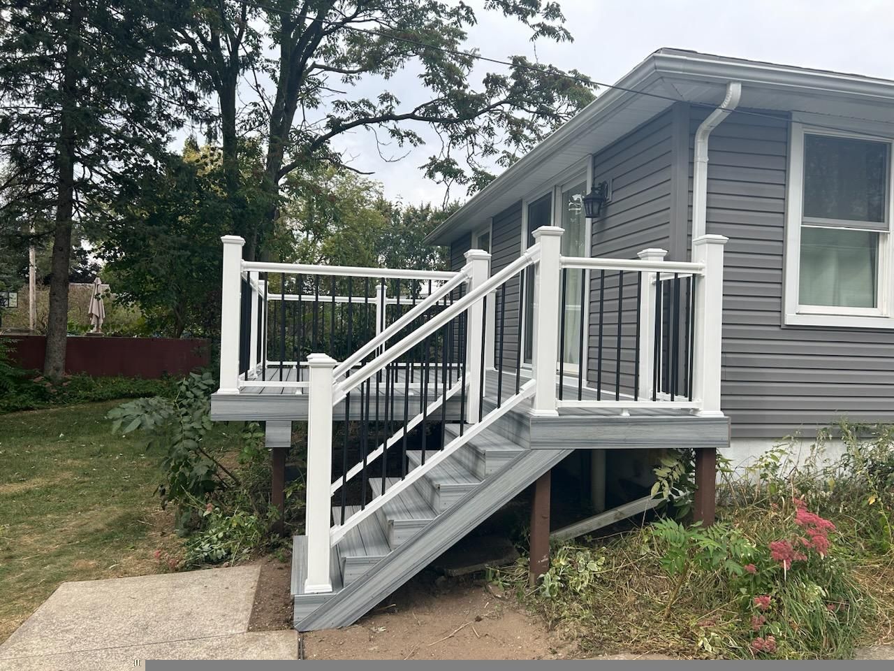 A house with a deck and stairs on the side of it.