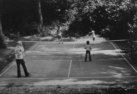 A black and white photo of people playing tennis