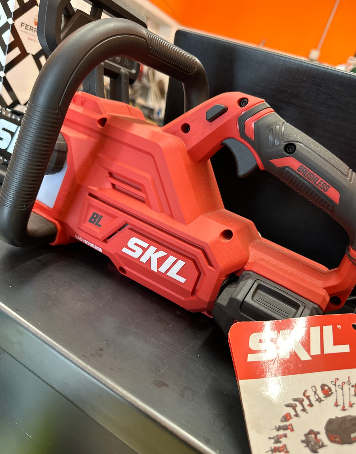 Una motosega rossa Skil è appoggiata su un tavolo