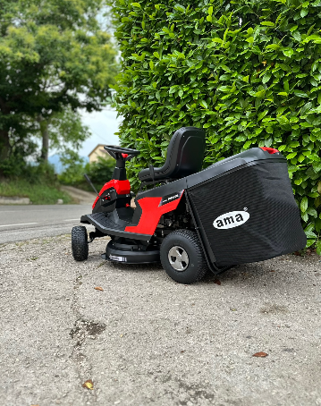 Un tosaerba è parcheggiato sul ciglio della strada, accanto a un cespuglio.