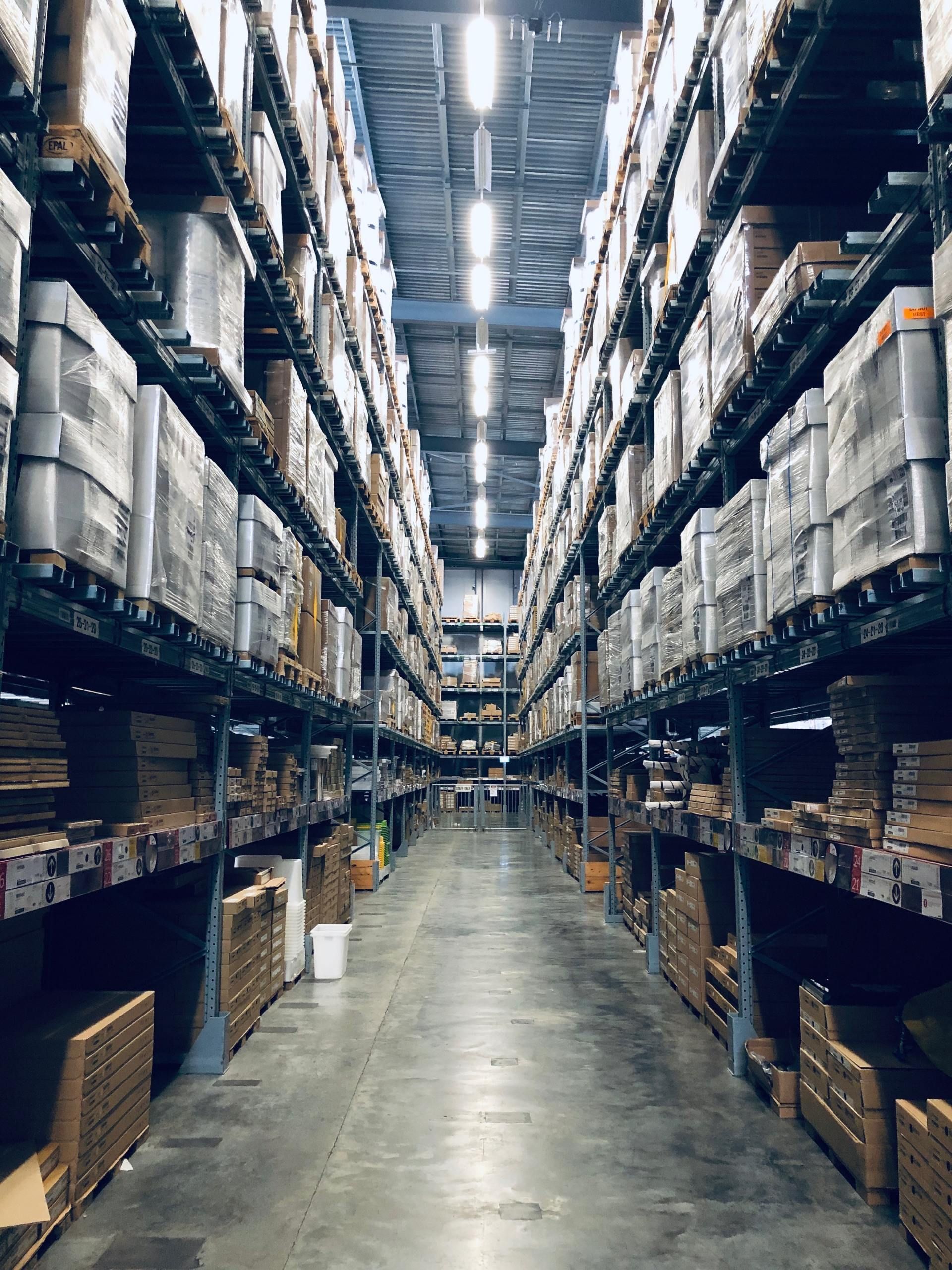 Warehouse interior with rows of shelves filled with boxes and products.