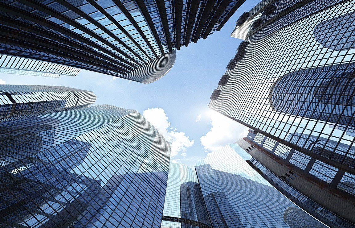 Skyscrapers reaching up toward a blue sky with wispy clouds.