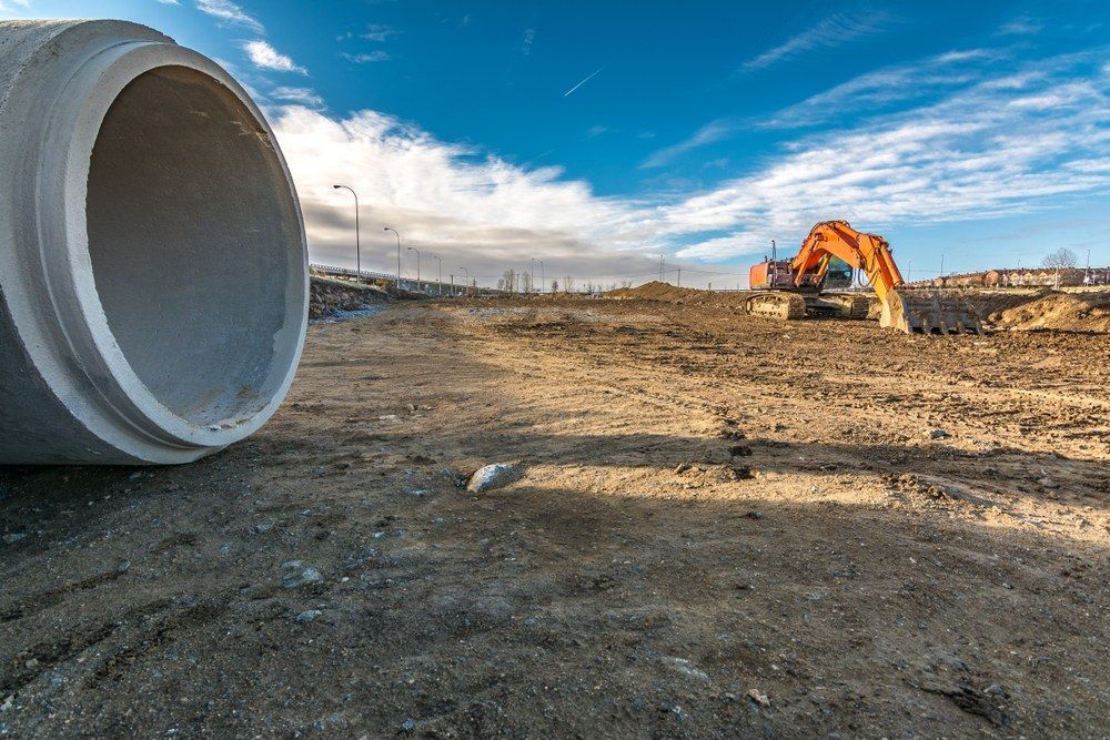 An Excavator is Sitting in the Middle of a Dirt Field — Jammach Earthmoving in Maitland, NSW