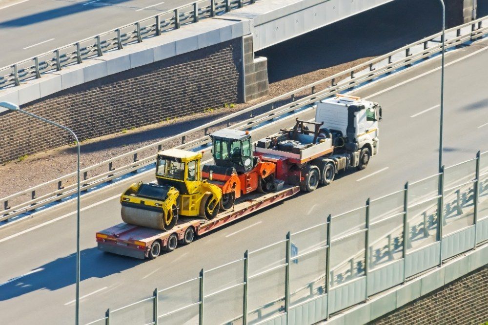 An Aerial View of a Truck Carrying Construction Equipment on a Highway — Jammach Earthmoving in Maitland, NSW