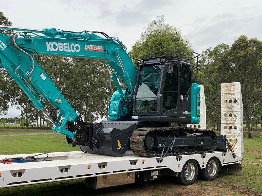 A Kobelco Excavator is Sitting on Top of a Trailer — Jammach Earthmoving in Maitland, NSW