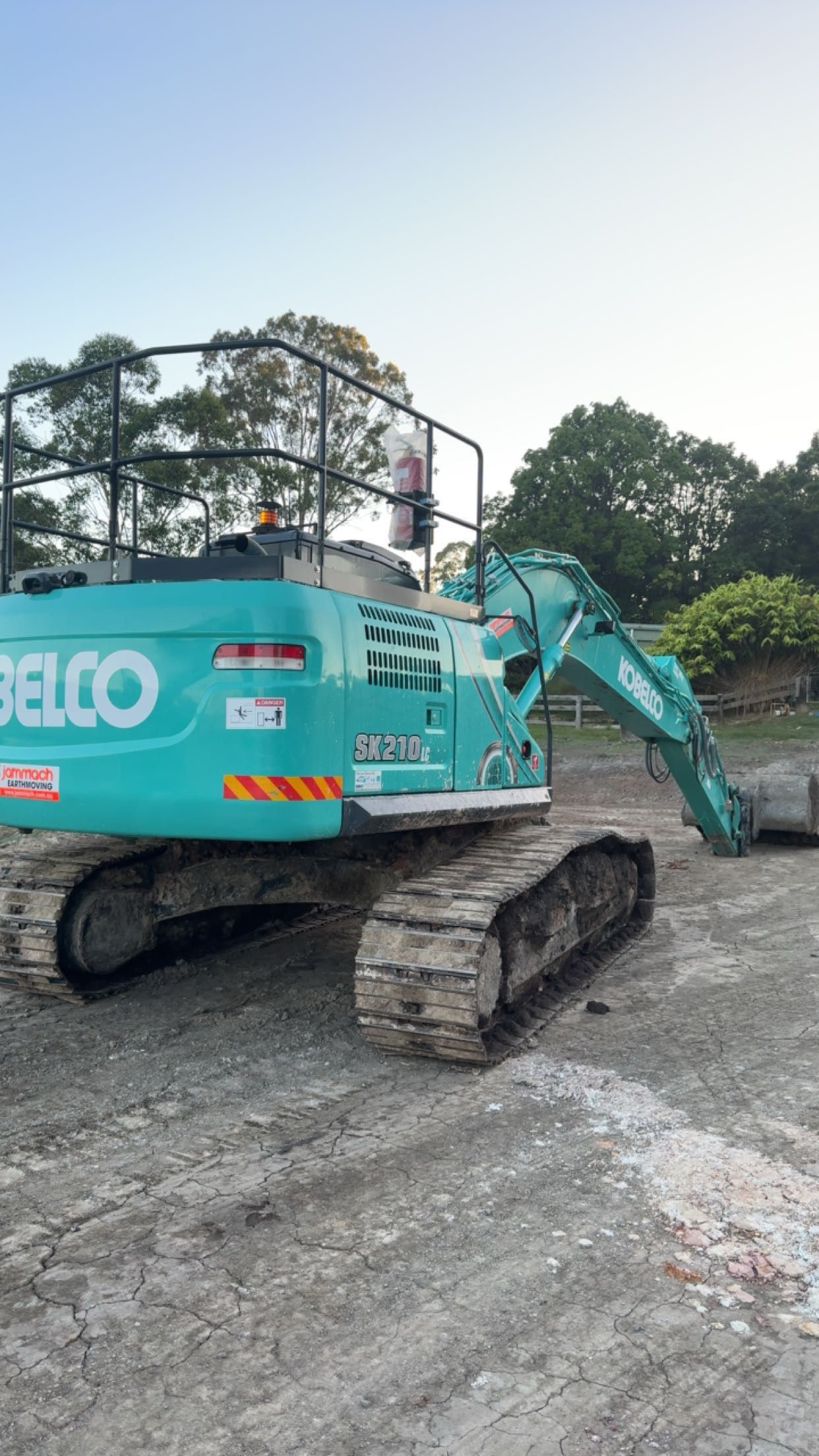 A Large Green Excavator is Parked in a Dirt Field — Jammach Earthmoving in Nulkaba, NSW