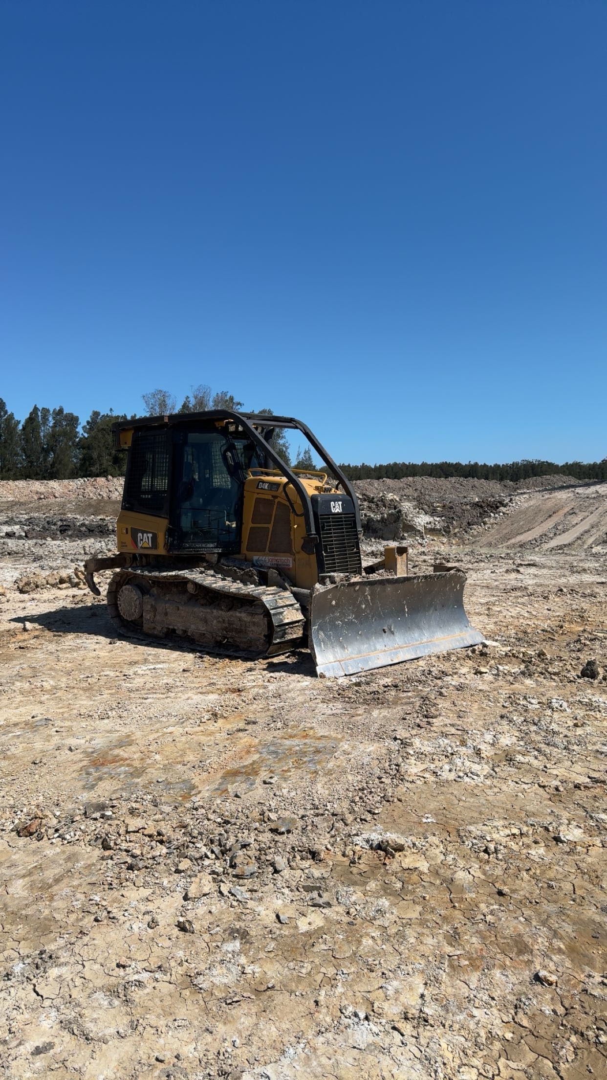 A Bulldozer is Driving Through a Dirt Field — Jammach Earthmoving in Nulkaba, NSW