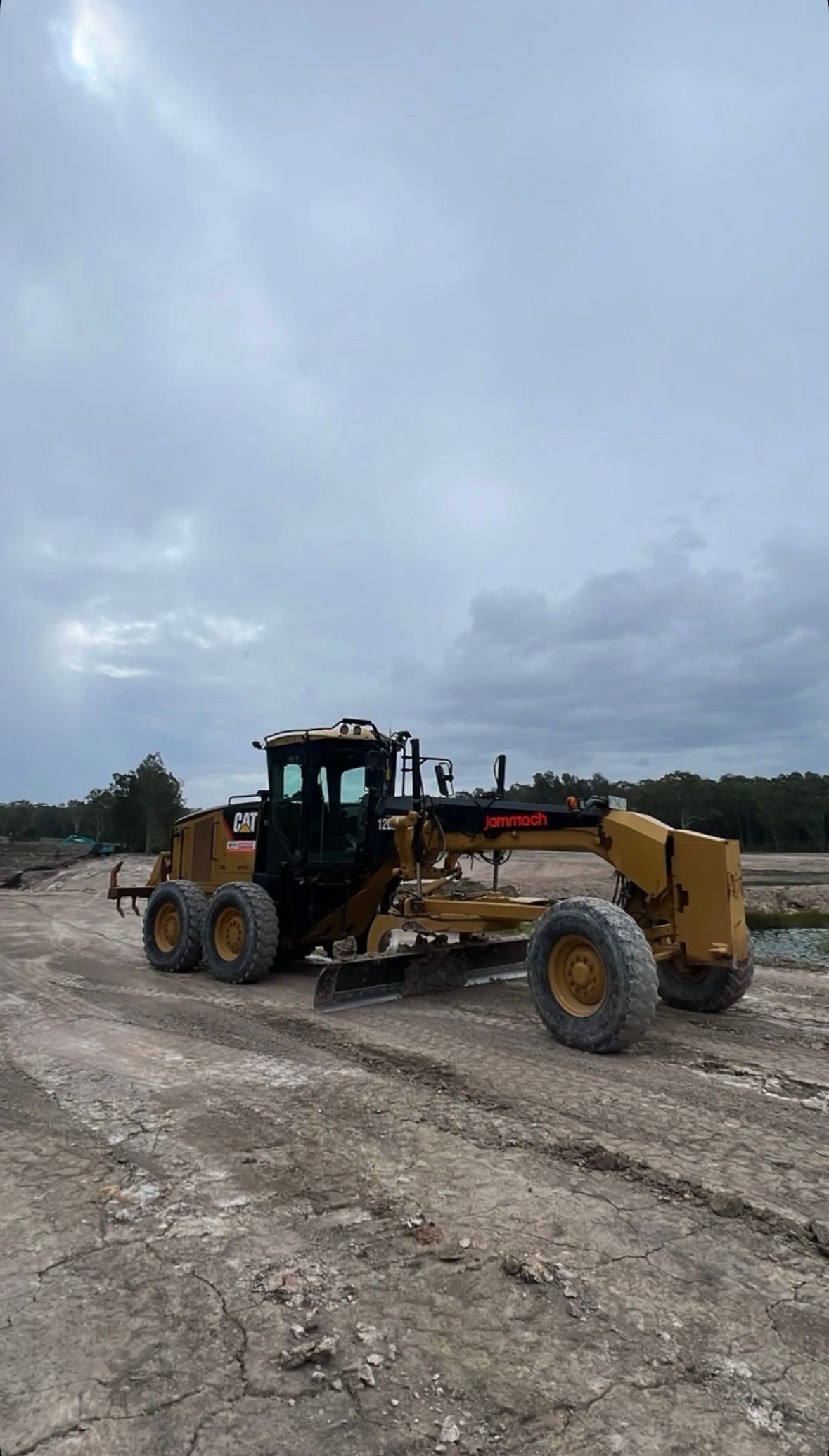 A Bulldozer is Parked in a Dirt Field on a Cloudy Day — Jammach Earthmoving in Nulkaba, NSW