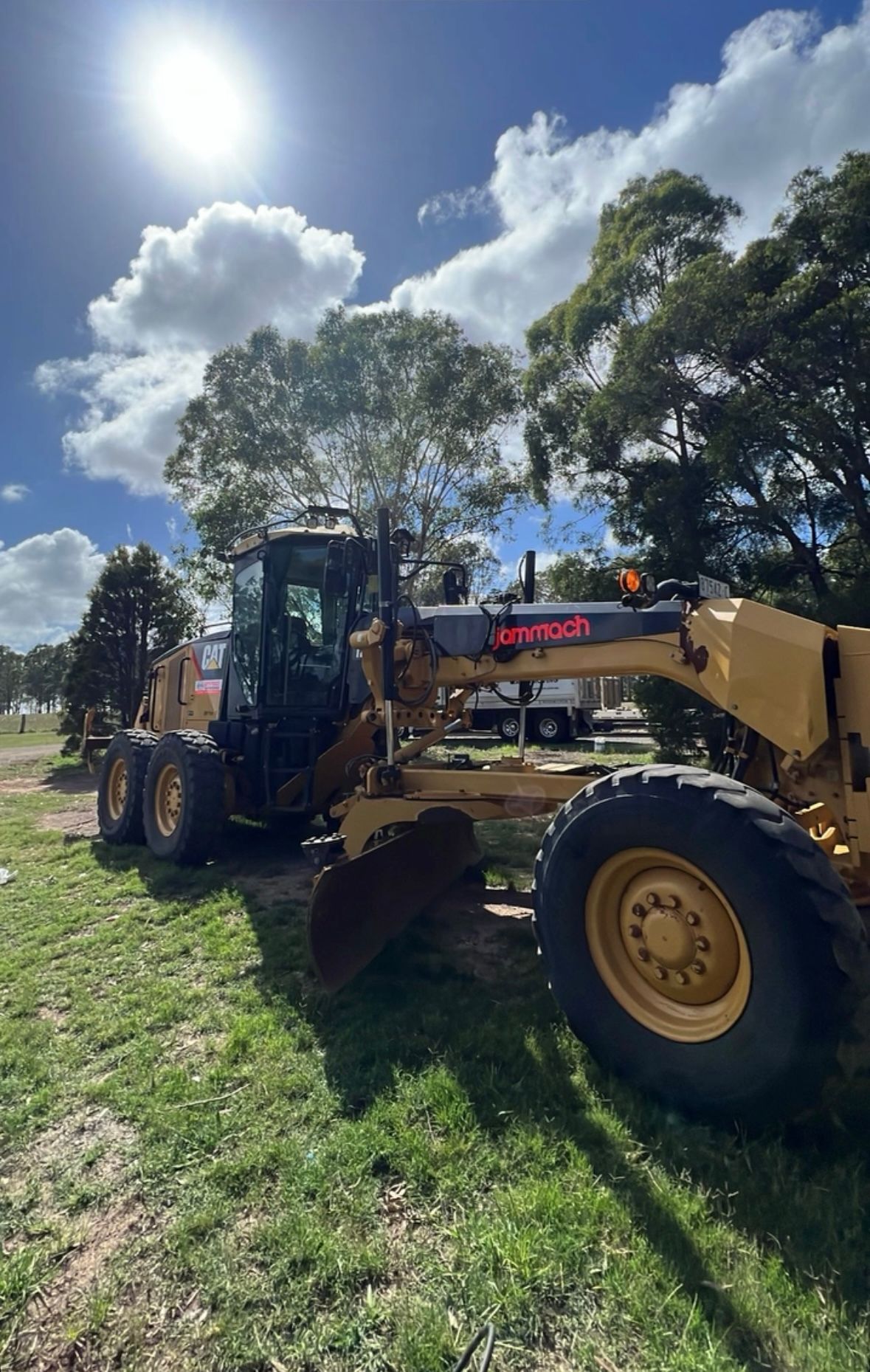 A Bulldozer is Parked in a Grassy Field on a Sunny Day — Jammach Earthmoving in Nulkaba, NSW