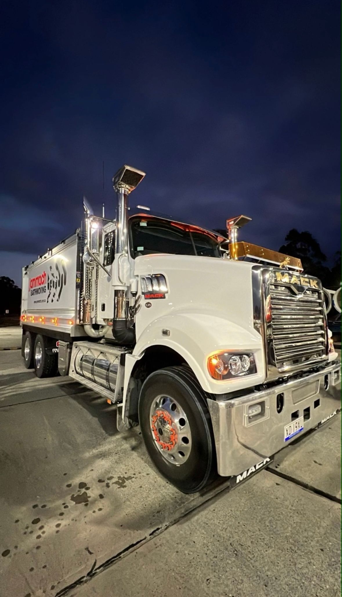 A White Semi Truck Is Parked In A Parking Lot At Night — Jammach Earthmoving in Nulkaba, NSW