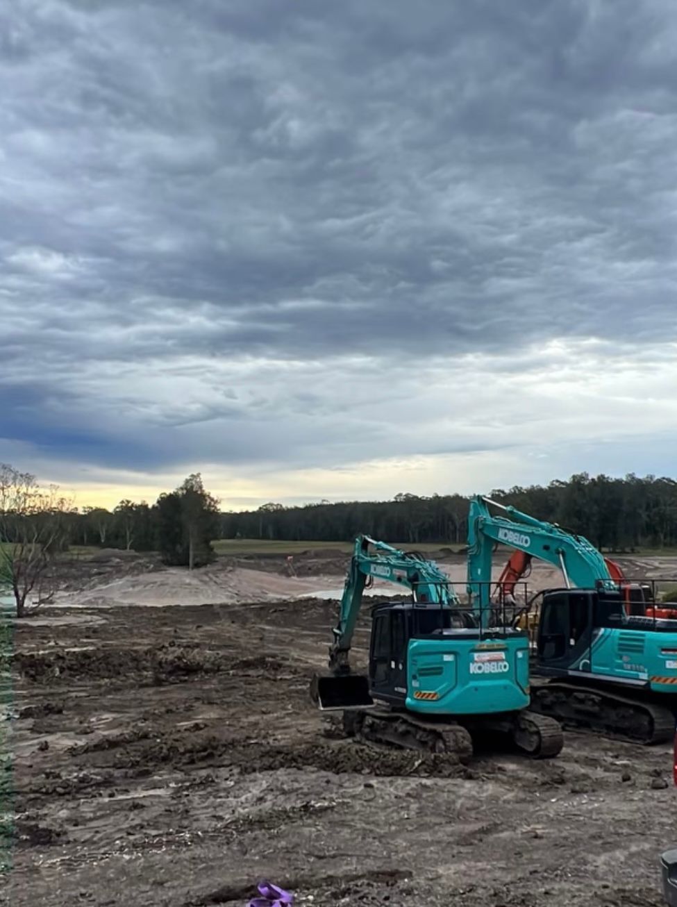A Couple of Excavators Are Sitting on Top of a Dirt Field — Jammach Earthmoving in Nulkaba, NSW
