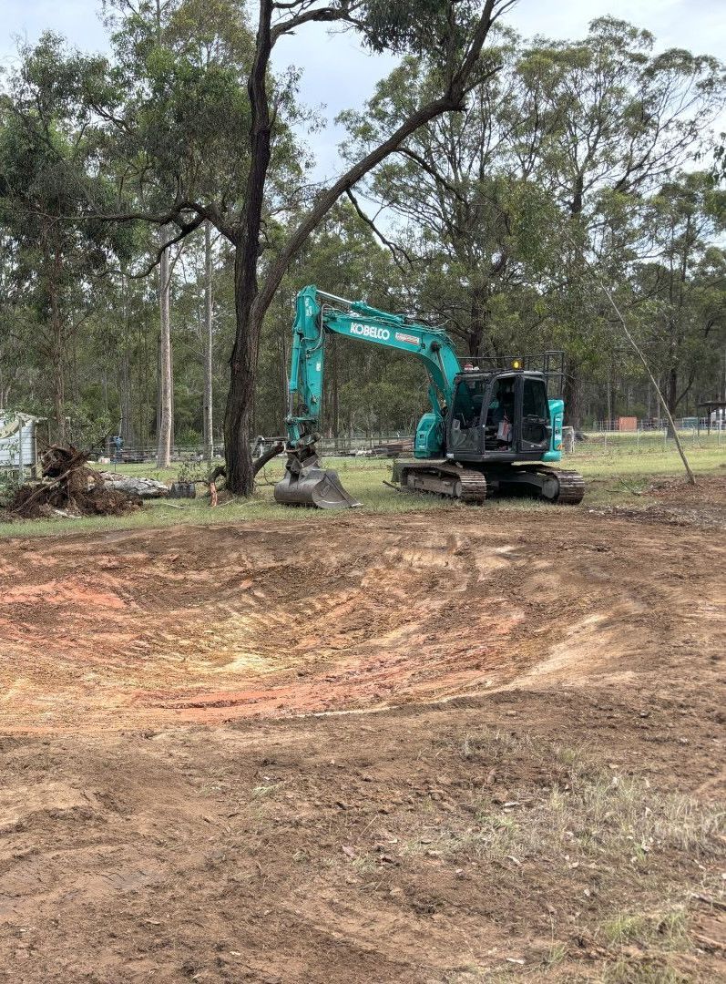 A Yellow Excavator Is Digging In A Pile Of Rocks — Jammach Earthmoving in Nulkaba, NSW