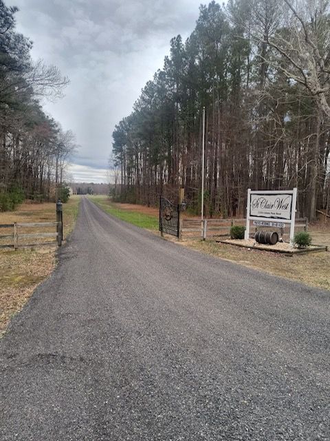 Gravel driveway leading to a sign for 