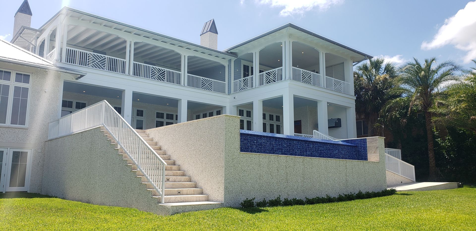 A large white house with a swimming pool in the backyard.