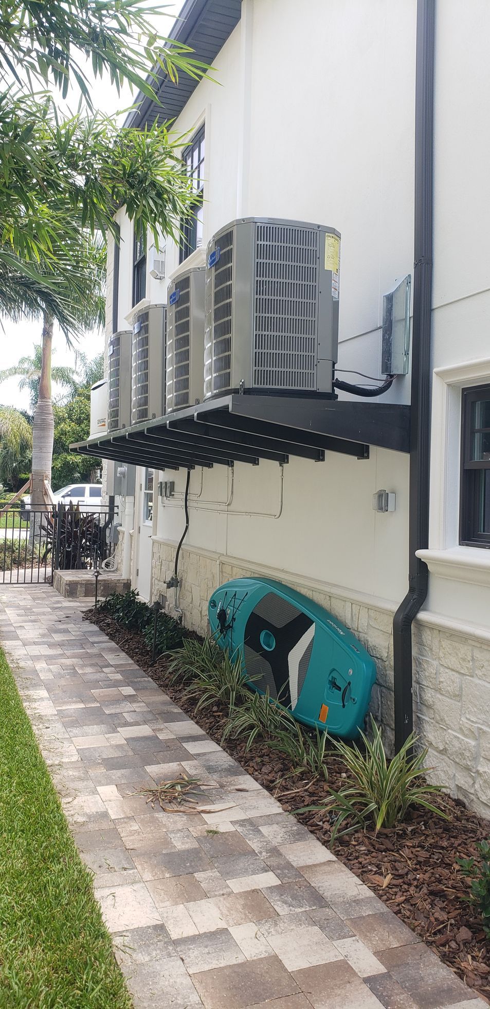 A house with a lot of air conditioners on the side of it.