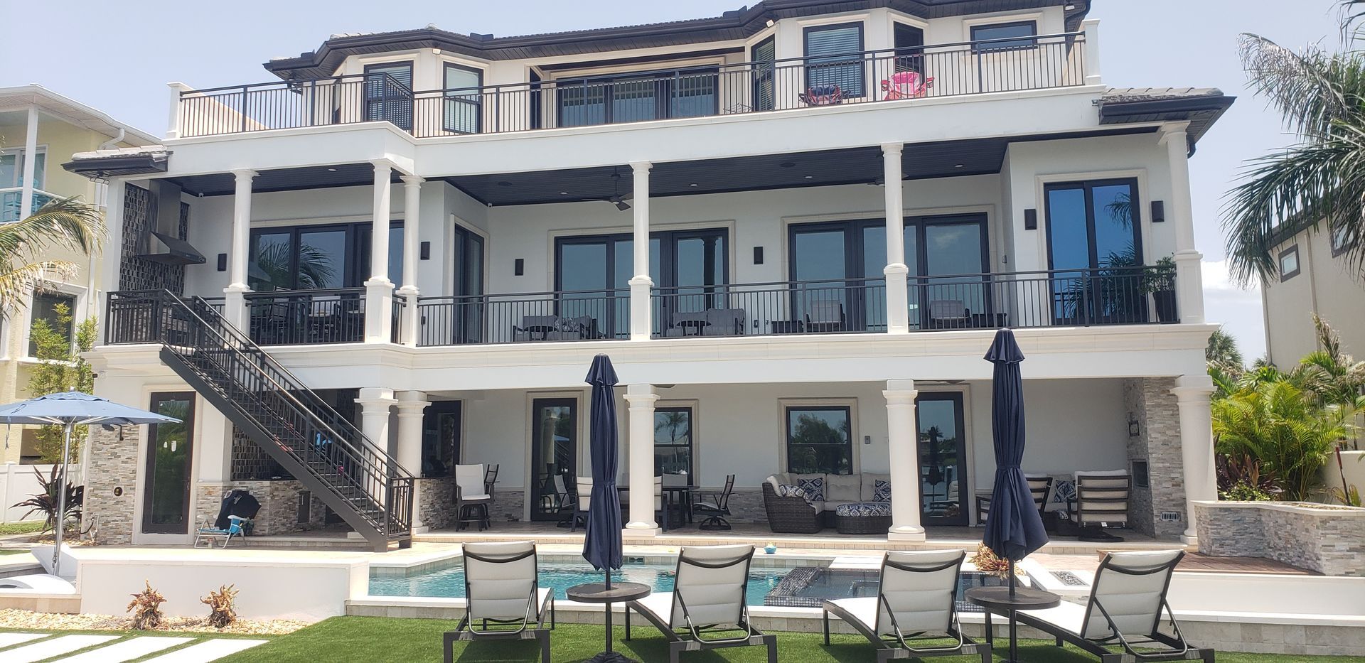 A large white house with a swimming pool in front of it.