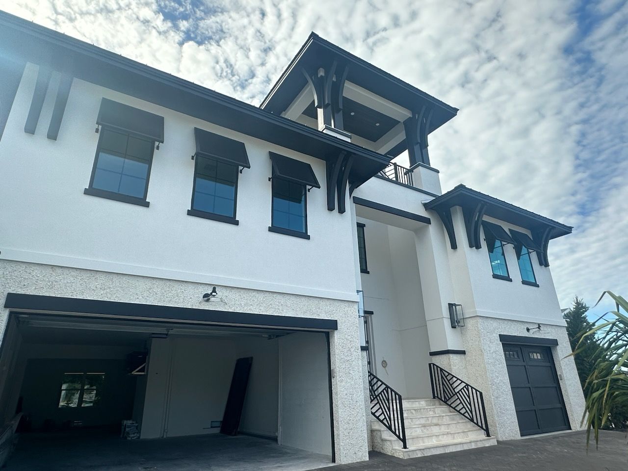 A large white house with black trim and a garage.